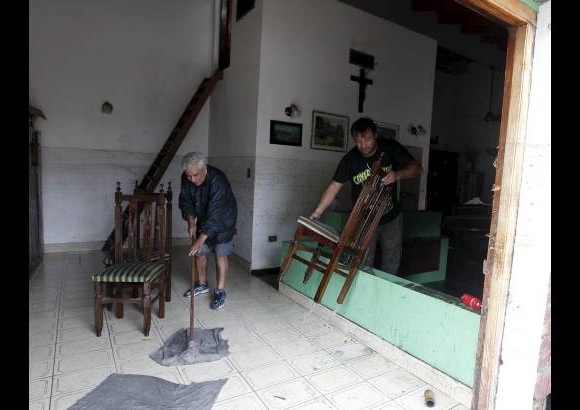 Reuters - Algunos residentes limpian su casa despu&#233;s de las fuertes lluvias que inundaron gran parte de la ciudad de La Plata.