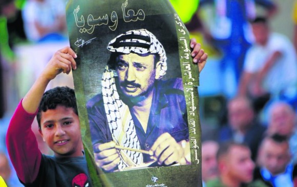 Desde ayer se realizaron homenajes al líder a lo largo de su país. En la localidad de Al-Yamoun este niño esgrime su imagen. FOTO AP