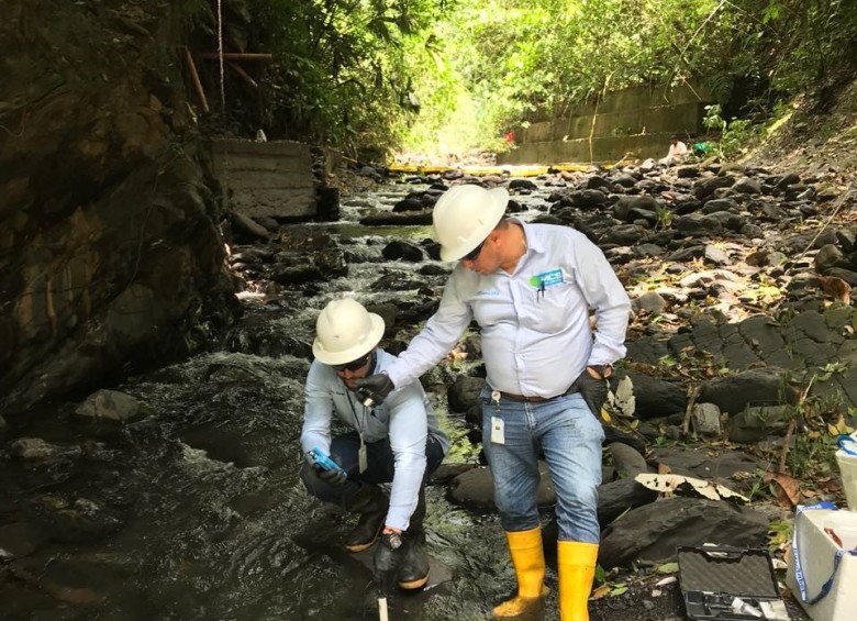 Funcionarios de la compañía petrolera recogen muestras del agua, para verificar si la quebrada La Cristalina resultó contaminada por el derrame de petróleo. FOTO cortesía de ocensa