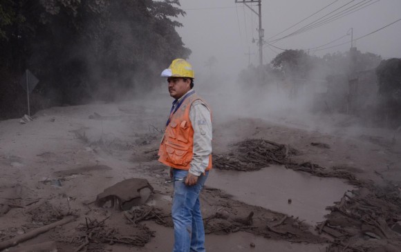 Un trabajador de la Coordinadora Nacional para la Reducción de Desastres de Guatemala observa los daños en El Rodeo, Escuintla. FOTO: EFE.