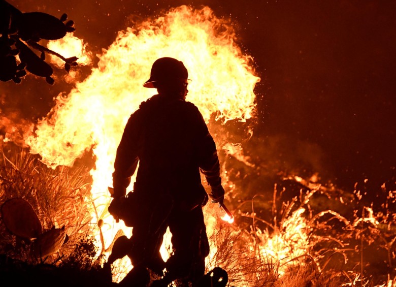 Los bomberos batallaban contra un gigantesco incendio forestal que azota el sur de California y que dejó un muerto, miles de evacuados y más de 150 casas y comercios destruidos. FOTO REUTERS