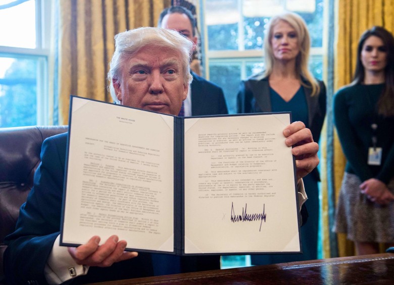 Donald Trump firmando la orden ejecutiva que sacó a Estados Unidos del TPP. FOTO AFP.