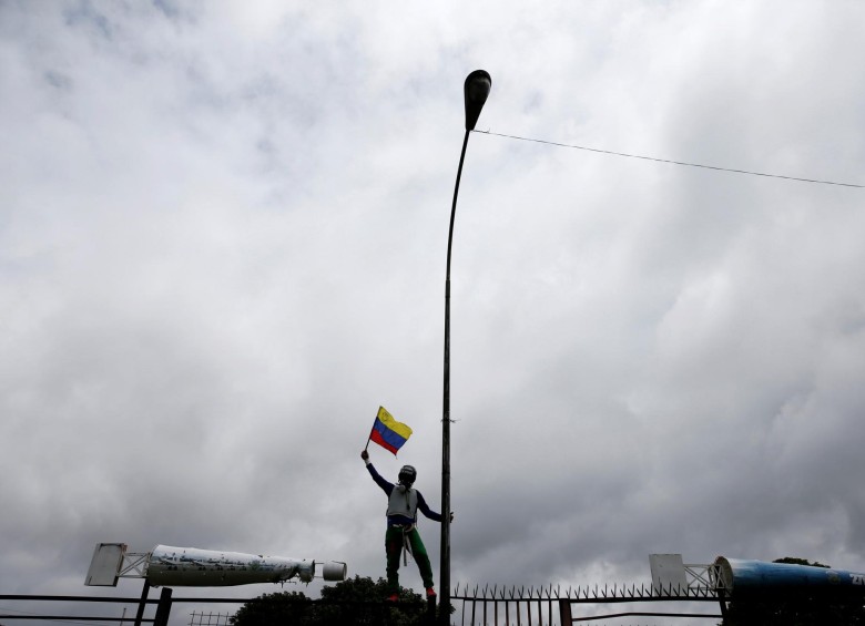 Sobre las rejas de la Base Aérea Francisco de Miranda los manifestantes ondean la bandera de su país. FOTO: REUTERS