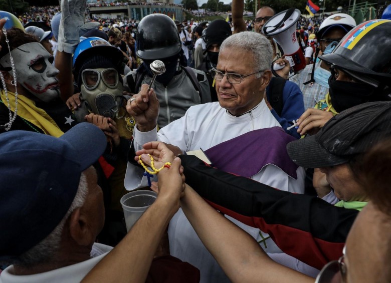 En la autopista Francisco Fajardo, un sacerdote bendice los elementos de los protestantes. FOTO: EFE