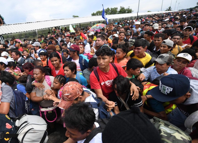 Miles de migrantes hondureños, que salieron en caravana de su país con destino a Estados Unidos, viven una tensa espera en el puente fronterizo entre México y Guatemala. AFP
