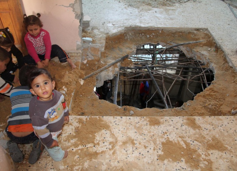 La casa de la familia Nusier, en la Franja de Gaza y los hijos de Khalil y Shaam entre las huellas que dejó el proyectil. La amenaza es latente para todo un vecindario que clama para que las autoridades desactiven el obús. FOTOS KHALED ALASHQAR