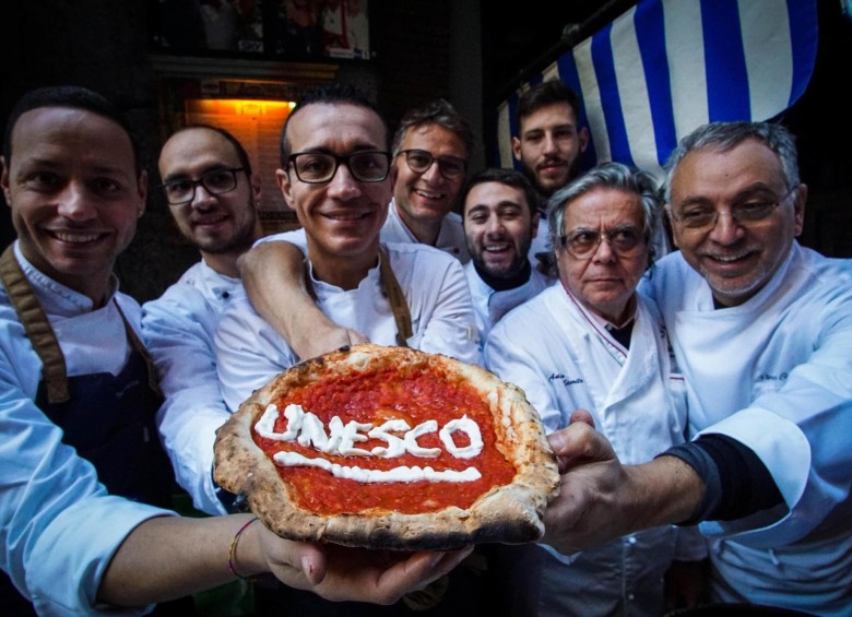 Los llamados pizzaoli celebraron el reconocimiento de la Unesco haciéndoles una pizza. FOTOS: AFP 