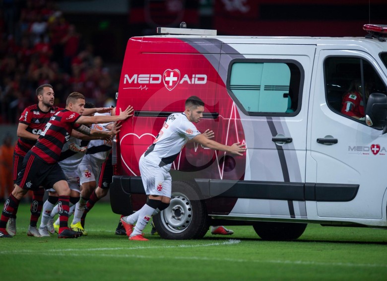 Jugadores de Flamengo y Vasco da Gama unieron fuerzas para ayudar a la ambulancia que llevaba en su interior al herido Bruno Silva. FOTO: AFP
