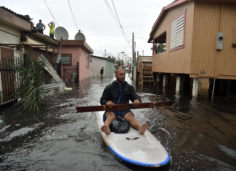 Un hombre navega por las calles de la barriada Juana Matos, en Cataño, Puerto Rico, tras el paso del huracán María. FOTO afp