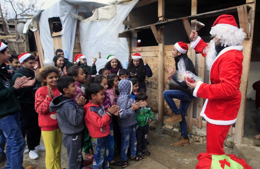 Estudiantes vestidos de Santa Claus entregaron regalos a niños de un campo de refugiados del conflicto en Siria, ubicado en Sidon. FOTO AP
