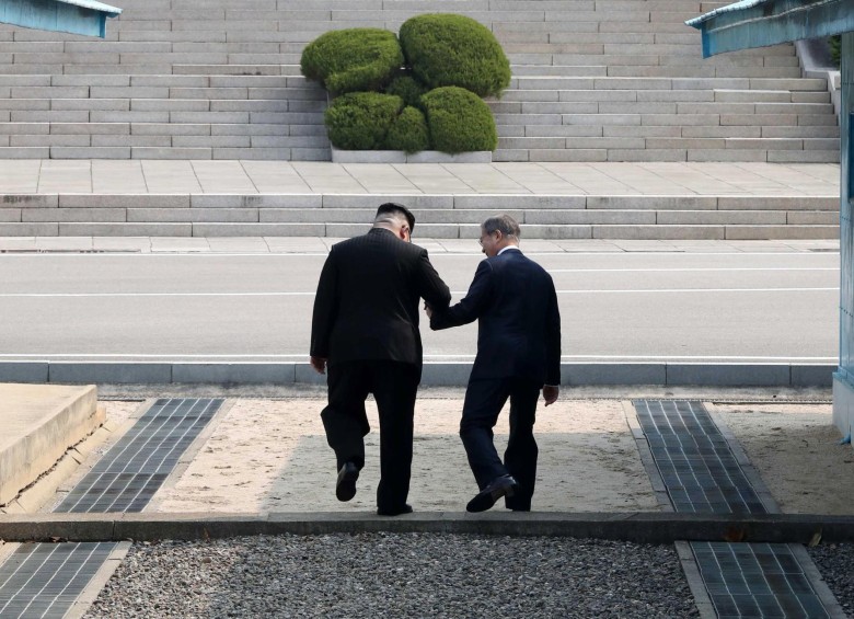 El presidente surcoreano, Moon Jae-in (d), y el líder del Norte, Kim Jong-un (i), caminan tomados de la mano en la línea de demarcación militar (MDL). FOTO EFE