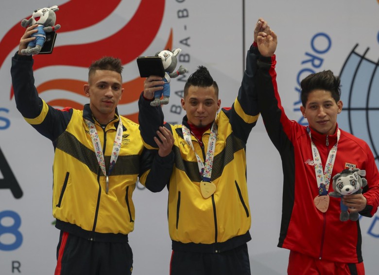 Los antioqueños Wílder Alejandro Posada y Carlos Berna (centro), lograron el 1-2 para Colombia, oro y plata en los 56 kilogramos, en el inicio del levantamiento de pesas en los Juegos Suramericanos, que se disputan en Cochabamba, Bolivia. FOTO EFE