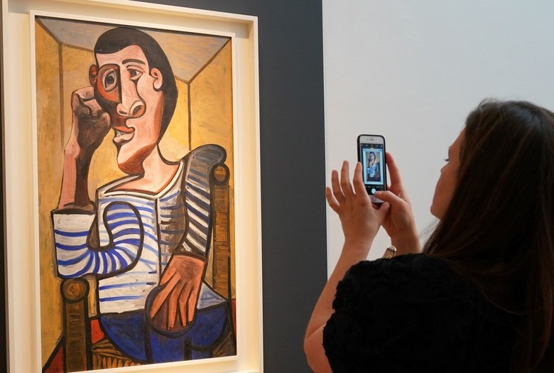 Una empleada de Christie’s fotografía ‘El marinero’, de Pablo Picasso, el pasado 3 de mayo en la casa de subastas, en Nueva York. Foto: AFP