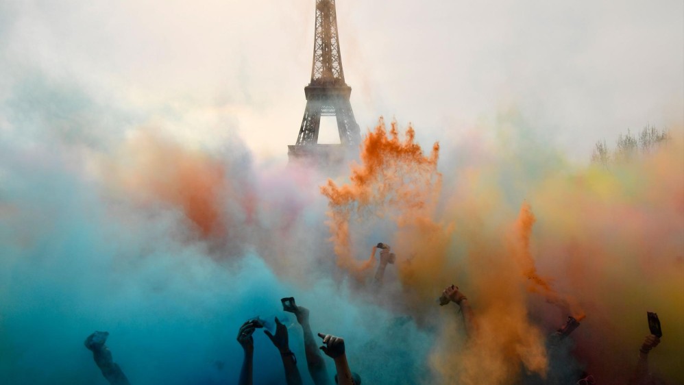 La gente celebra al final de la carrera Color Run 2018 frente a la Torre Eiffel en París. Foto: CHRISTOPHE SIMON
