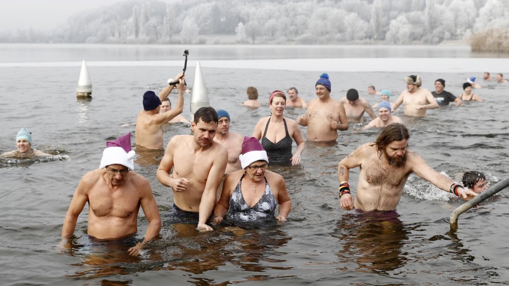 Los suizos acostumbran a nadar en el agua helada del lago Moossee el 31 de diciembre. La temperatura ambiente es de -3 grados centígrados. FOTO AP