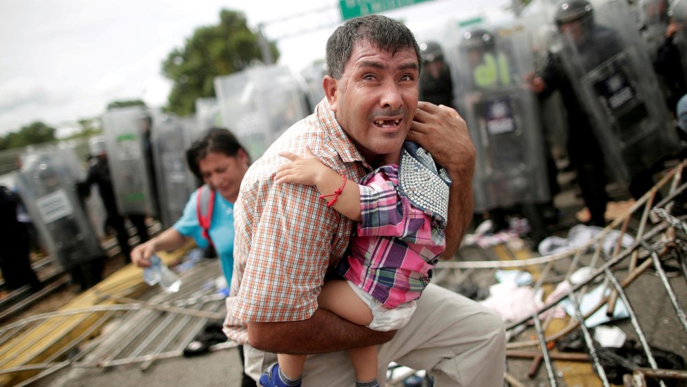 Un hondureño sostiene a su pequeño hijo, en Guatemala. Mayo. Foto: Reuters