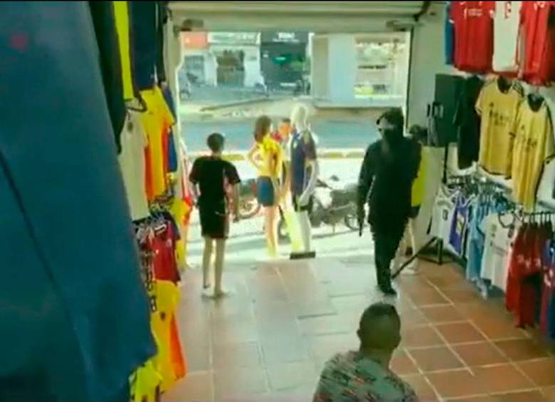 Uno de los presuntos ladrones tenía un arma de fuego con la que intimidó al vendedor de camisetas deportivas. FOTO: CAPTURA DE PANTALLA 