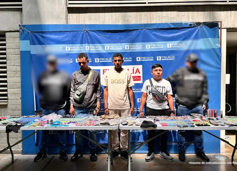 Tres de los capturados en Barrio Antioquia y parte de la mercancía incautada. FOTO Cortesía Secretaría de Seguridad de Medellín.