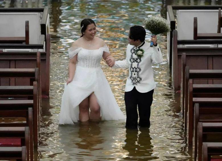 La pareja caminando en el agua en la iglesia donde se casaron. FOTO: Tomada de redes sociales