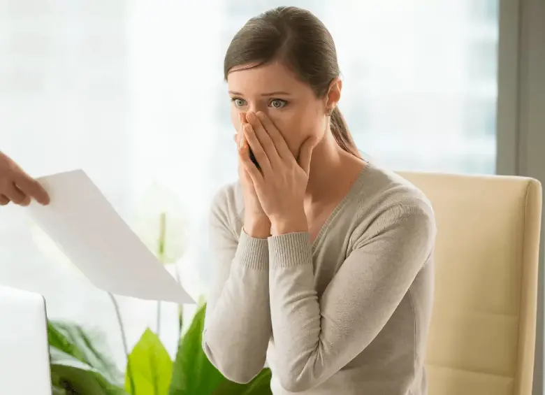 Trabajadora revisando documentos laborales tras la terminación de su contrato sin justa causa. FOTO: SHUTTERSTOCK