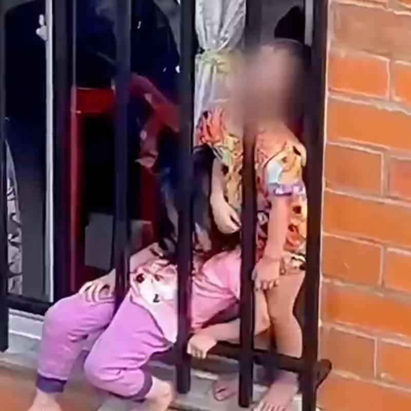 Dos menores en una ventana genera investigación por presunto maltrato infantil en Risaralda. FOTO: Captura de video 