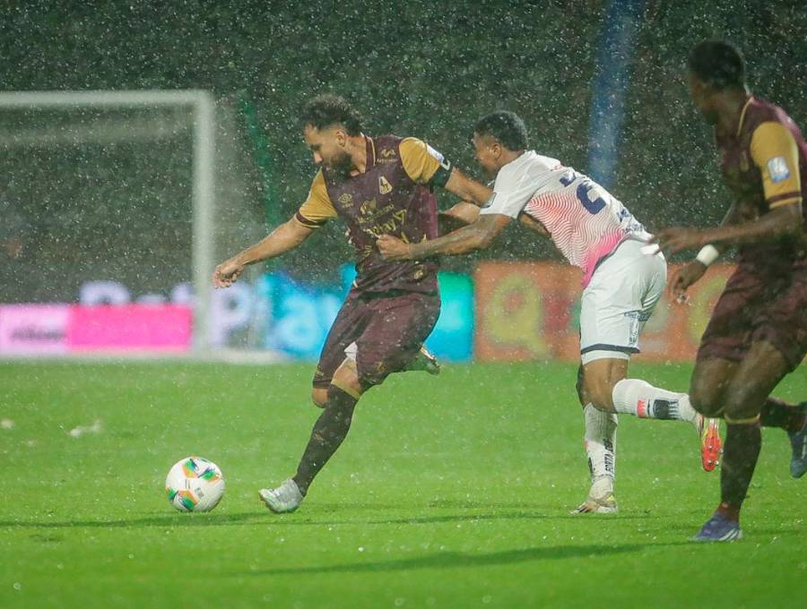 Juan Pablo Nieto protege en balón en un campo difícil por la lluvia en Bogotá. FOTO COLPRENSA