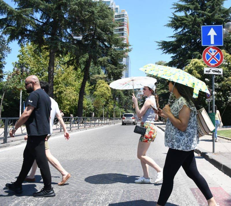 Las personas van con sombrillas debido al intenso calor. FOTO: AFP