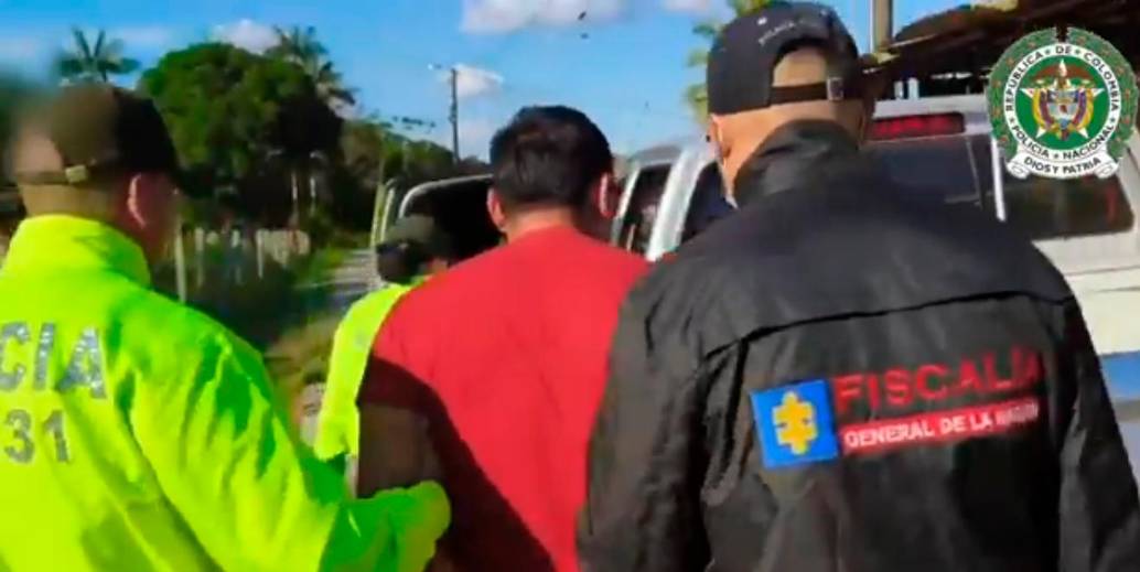 Uno de los capturados, conducido por los investigadores a la patrulla policial. FOTO: CORTESÍA DE POLICÍA.