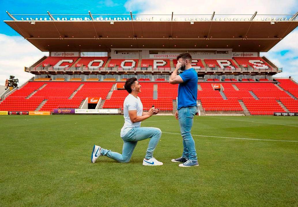 Josh Cavallo, de rodillas, le pide matrimonio a su pareja Leighton Morrell, en el estadio Hindmarsh.<b> </b>FOTO: Tomada de Instagram @joshua.cavallo