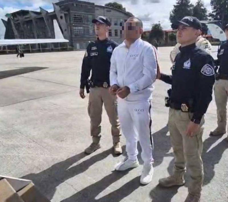 Uno de los capturados, vestido de blanco, a punto de subir al avión para su extradición. FOTO: CORTESÍA ARMADA NACIONAL