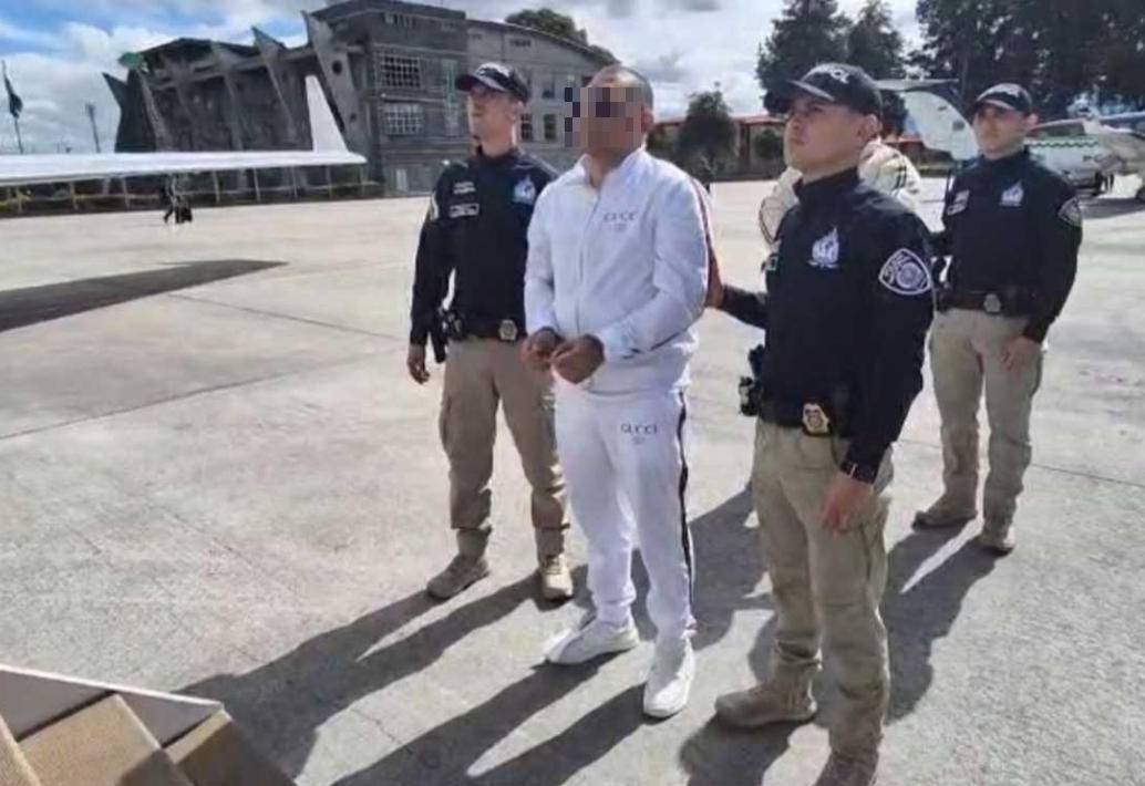 Uno de los capturados, vestido de blanco, a punto de subir al avión para su extradición. FOTO: CORTESÍA ARMADA NACIONAL