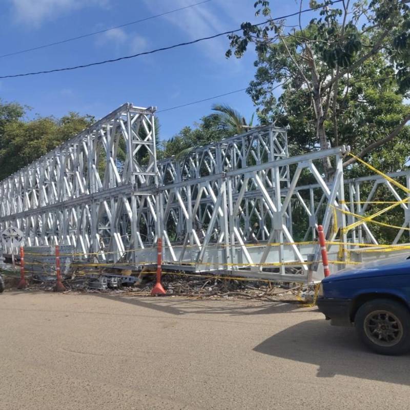 El puente ya está casi armado en uno de los costados de la vía, pero sigue sin ser instalado sobre el río. FOTO: Cortesía.
