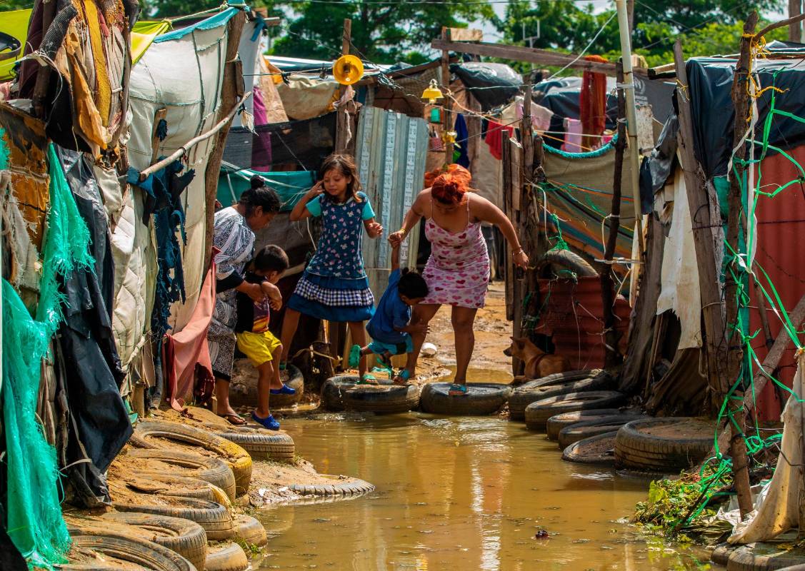 Las aguas se metieron a los ranchos improvisados y las familias tienen que crear caminos de llantas. FOTO: Camilo Suárez.