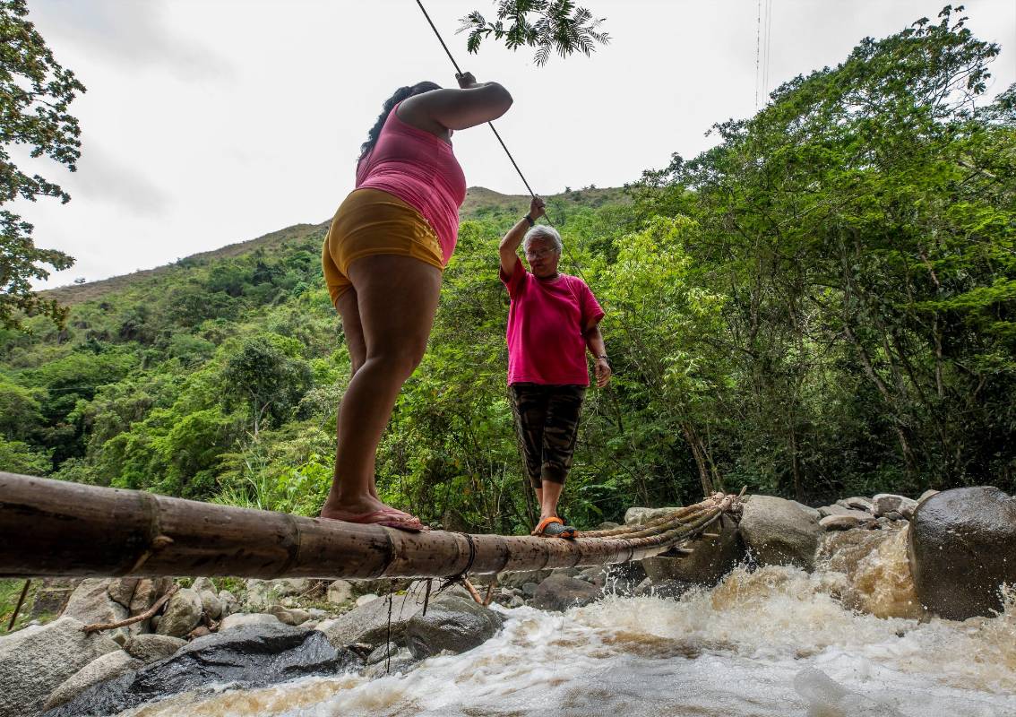 Marcela Tilano y Marleny Ramírez, dos habitantes del sector que cada día arriesgan su vida al cruzar el río. Foto: Camilo Suárez