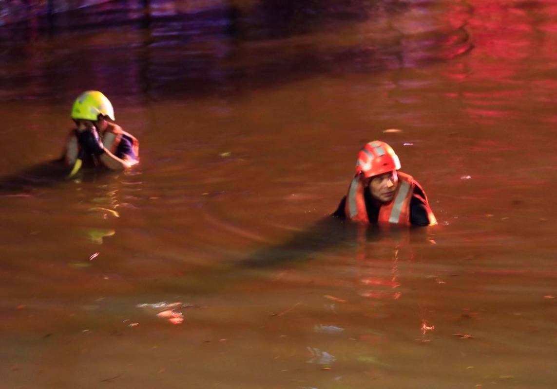 Durante las maniobras de rescate, los socorristas tuvieron que nadar en una calle inundada hasta los 1,55 metros para llegar al carro. FOTO CAMILO SUÁREZ