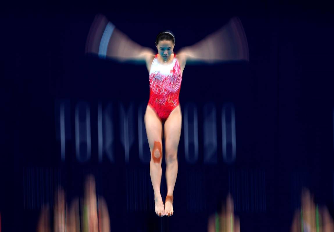 Han Wang del Equipo China realiza calentamiento antes de las Finales de trampolín de 3 metros femeninos en el Centro Acuático de Tokio. Foto Getty