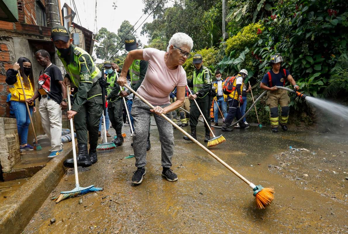 En Santo Domingo en la vía principal, la gente del barrio y las autoridades de gestión de riesgo limpian las calle del barro que dejó la ola invernal. Foto: Manuel Saldarriaga Quintero.