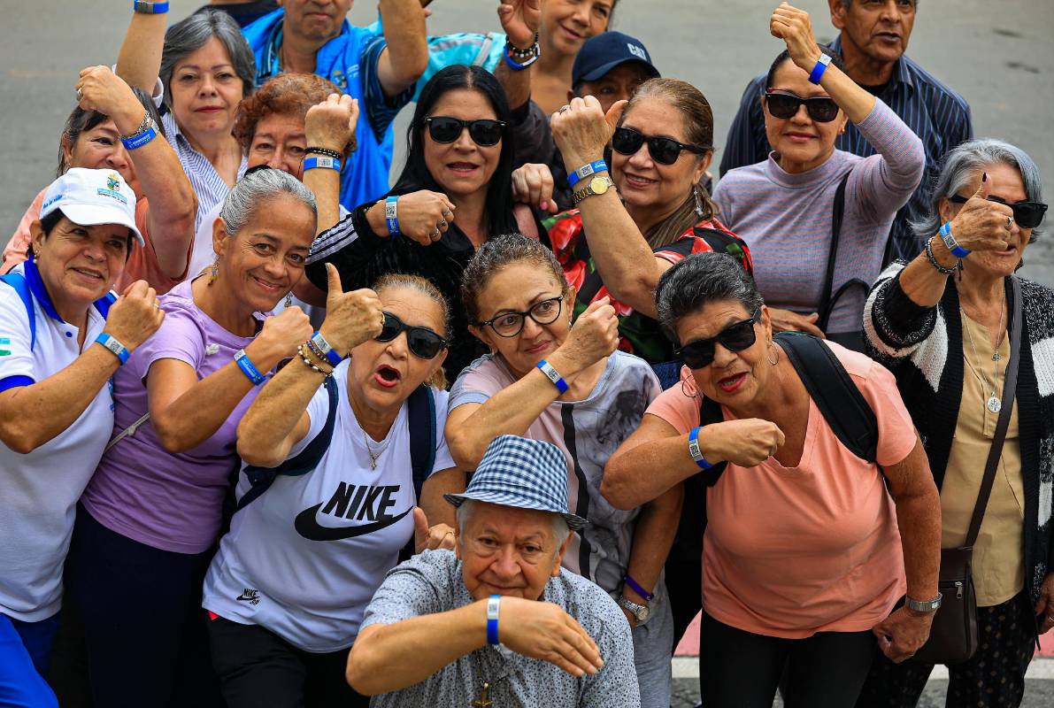 Grupo de adultos mayores en La Estrella muestran las manillas de código QR. Foto: Manuel Saldarriaga