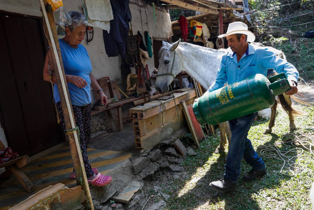 Los vecinos reciben a don Gustavo y Jalisco con gran aprecio cuando llegan con el domicilio. Foto: Manuel Saldarriaga Quintero.