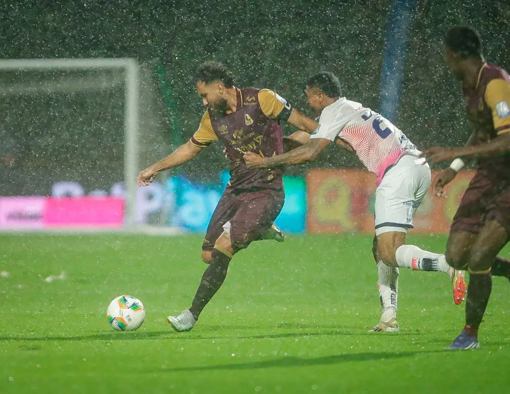 Juan Pablo Nieto protege en balón en un campo difícil por la lluvia en Bogotá. FOTO COLPRENSA