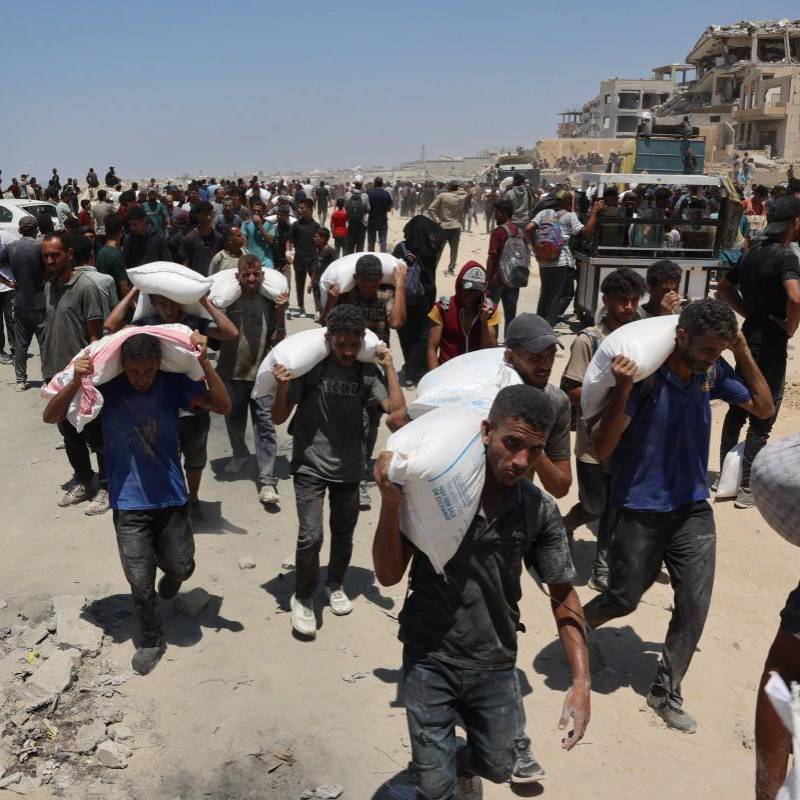 La gente camina por la calle al-Rashid, en el oeste de Jabalia, después de recibir ayuda humanitaria desde un punto de distribución de ayuda en el norte de la Franja de Gaza. FOTO: AFP