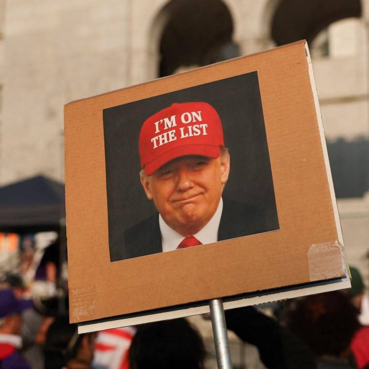 Una persona sostiene una fotografía del presidente Donald Trump con un sombrero rojo que dice “Estoy en la lista” frente al Ayuntamiento de Los Ángeles. FOTO: AFP. 
