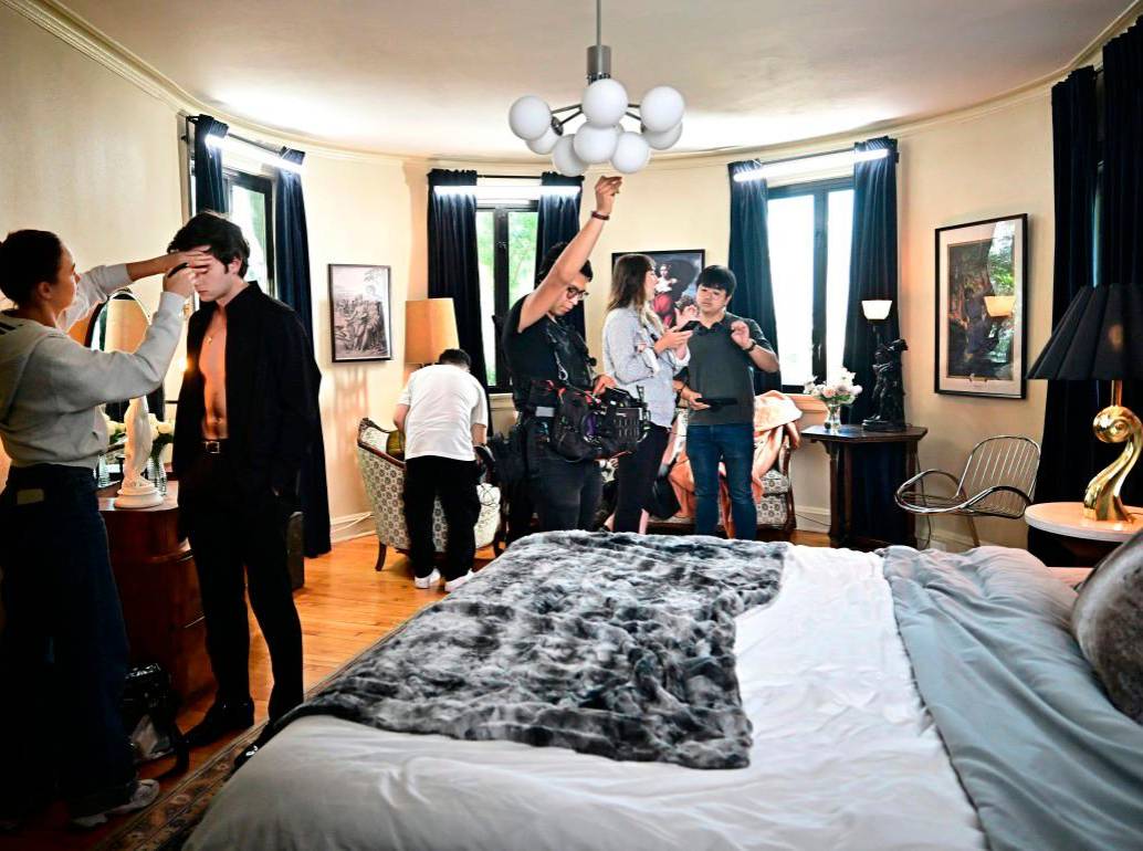 El actor ucraniano Zachary Shadrin (2º izq.) se maquilla mientras el director chino Weiyang Li (der.) comenta una escena durante el rodaje del drama vertical “Love Through All Seasons”. Foto: Afp.