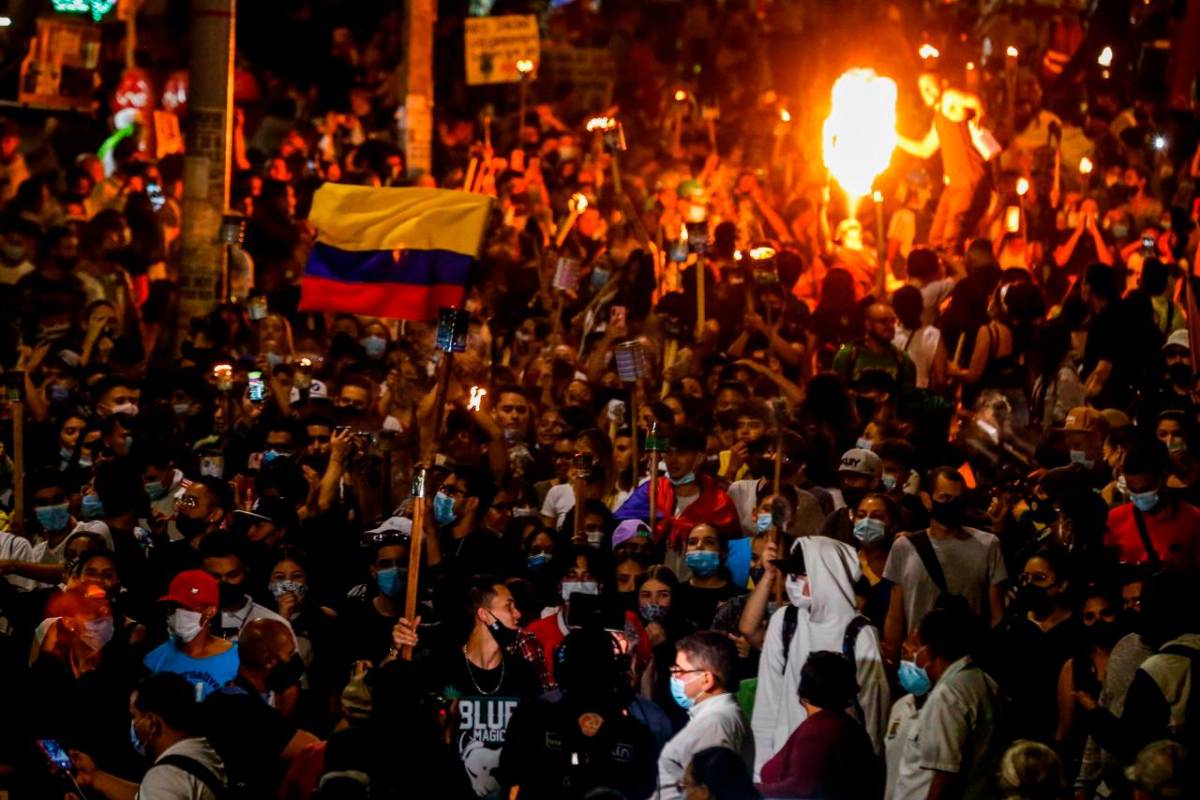 A esta hora avanza, en completa calma, una marcha de antorchas en la comuna 5, barrio Castilla de Medellín. Foto Julio César Herrera