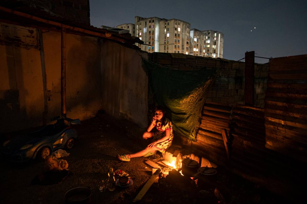 Niña indígena cocina en leña durante la noche en un inquilinato del sector de Niquitao en Medellín. Foto: MANUEL SALDARRIAGA QUINTERO.