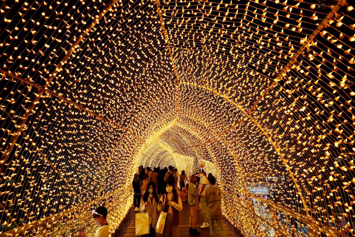 Aprovechando las luces de este año, en la ciudad de New, Taiwán, los habitantes se toman fotos bajo los adornos navideños . FOTO EFE