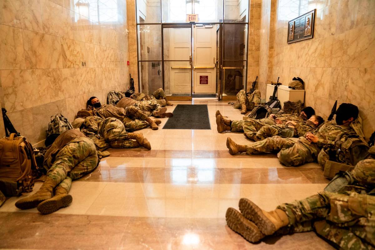 Miembros de la Guardia Nacional de los Estados Unidos duermen en los pasillos del Capitolio para prevenir nuevos desmanes, horas antes del debate por el juicio político a Donald Trump por la invasión de este recinto por parte de sus seguidores. Fotos: Kent Nishimura (Los Angeles Times) vía Getty.