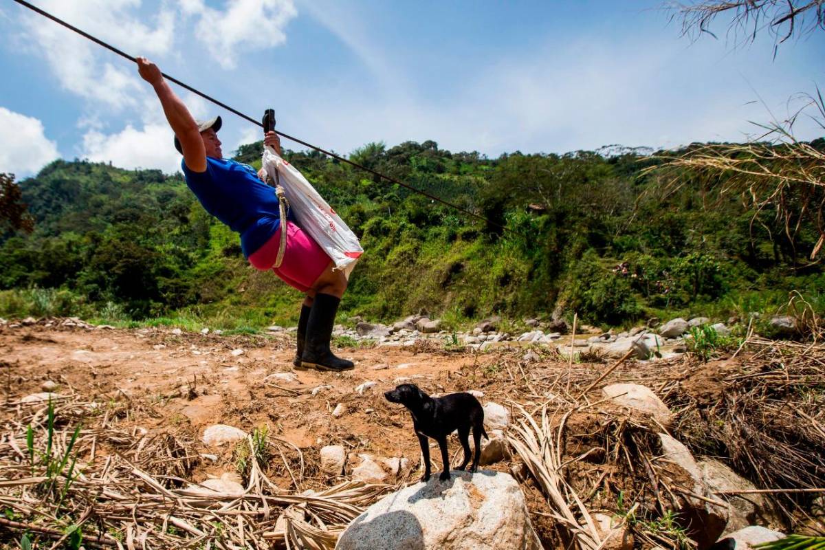 En el oriente Antioqueño desde hace 16 años, cerca de 10 familias deben hacer esta osada actividad de manera cotidiana para cruzar el río Tafetanes. FOTO JULIO CÉSAR HERRERA
