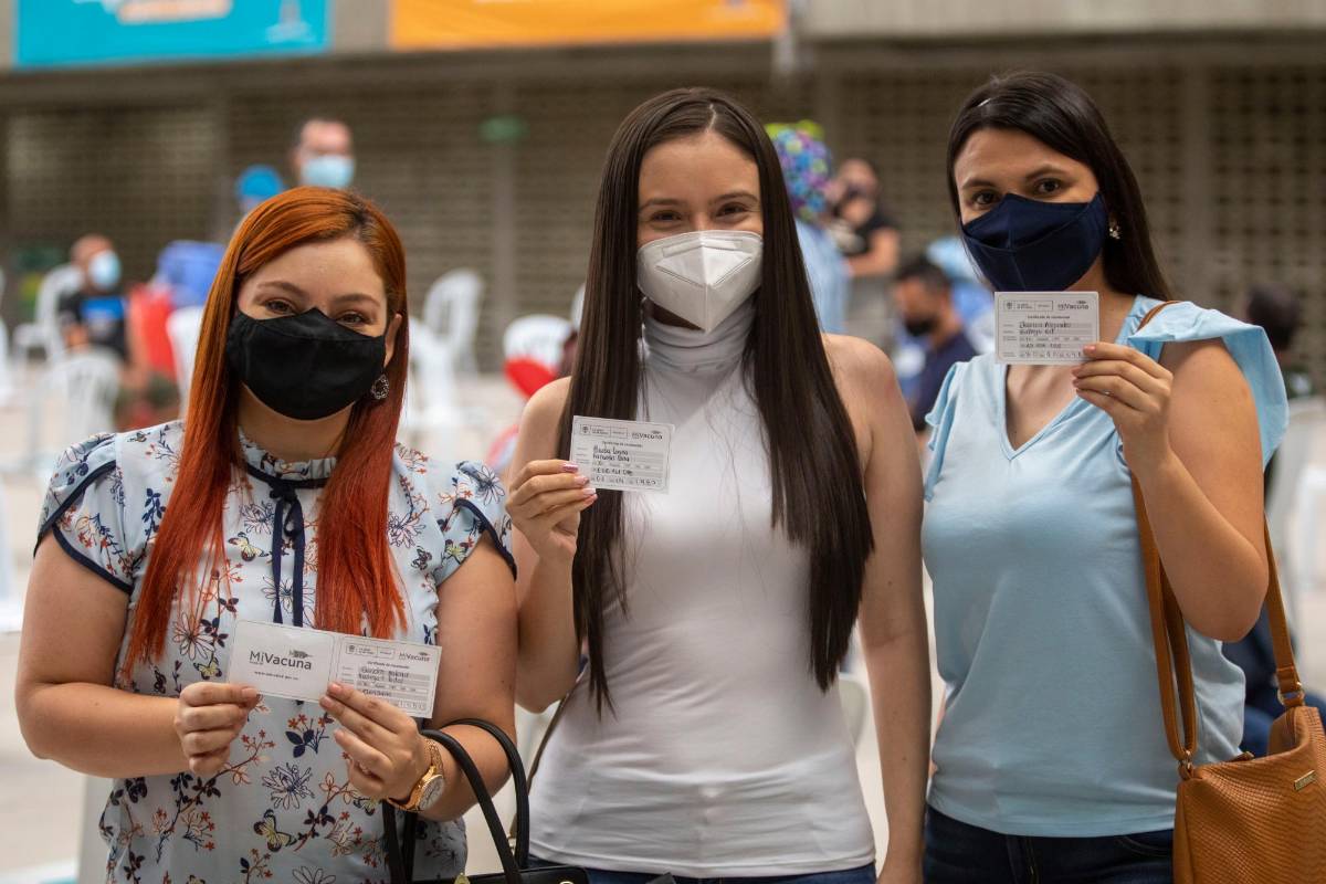 Grupo de vacunados exhibe con orgullo el carné de vacunación, realizado en el Coliseo Yesid Santos, en la Unidad Deportiva Atanasio Girardot. Foto: Edwin Bustamante