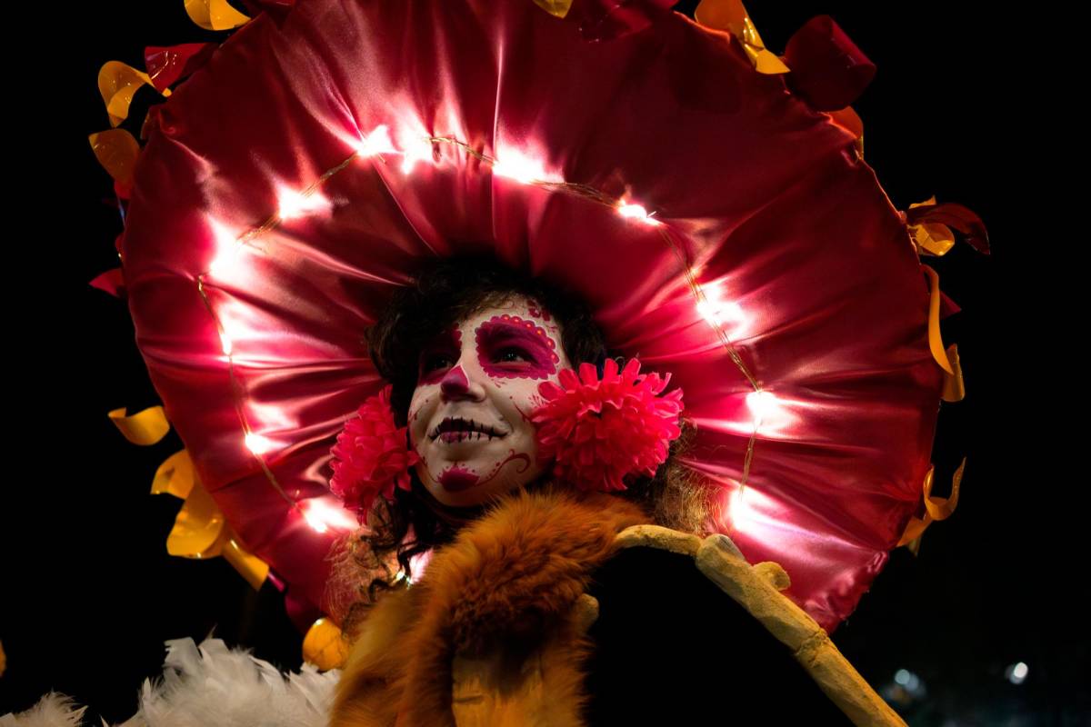 Decenas de bailarines desfilaron por Paseo de la Reforma, una de las avenidas más importantes de la capital, ataviados como esqueletos o con inmensas máscaras de cráneos. FOTO Getty